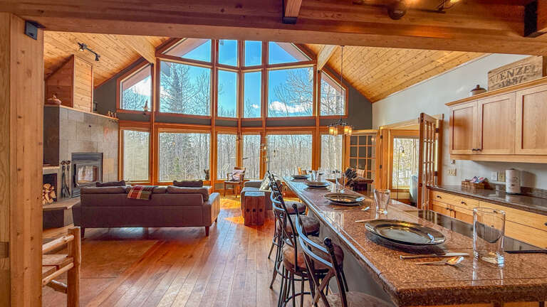 Stunning open-concept living with soaring cathedral ceilings and floor-to-ceiling windows flooding your space with natural light and forest views.