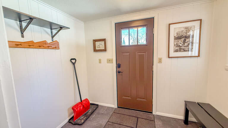 Your cozy entryway welcomes you with practical storage, wall hooks for your gear, and a warm bench to settle in.