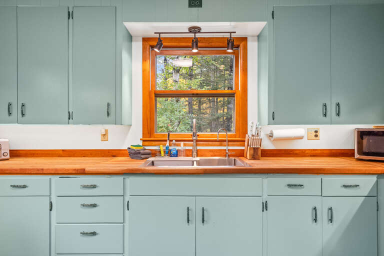 Whip up your favorite meals in this bright, vintage-inspired kitchen, where warm wood countertops and cheerful mint cabinets create a welcoming space for cooking and gathering.