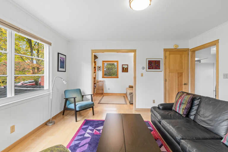 Relax in your bright, open living space with cozy seating, warm wood accents, and beautiful autumn views through the windows—your peaceful retreat awaits.