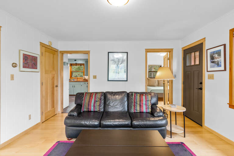 Step into your welcoming living space, where a plush leather sofa invites you to unwind after a day of exploring. The warm wood accents and thoughtfully curated art make this room feel like home.