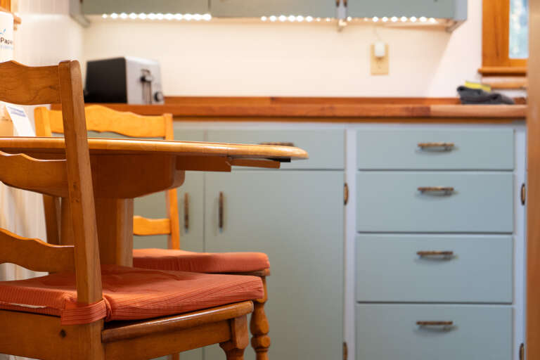 Settle into your charming kitchen space, where warm wood accents and soft lighting create a cozy spot for morning coffee or preparing your favorite meals.