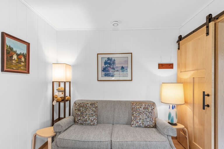 Sink into the plush sofa and feel the day's stress melt away in your cozy, bright living space with warm lighting and charming rustic touches.