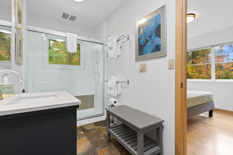 Step into your bright, modern bathroom where crisp towels await and natural light streams through the window. The walk-in shower and fresh finishes create a peaceful space to refresh.