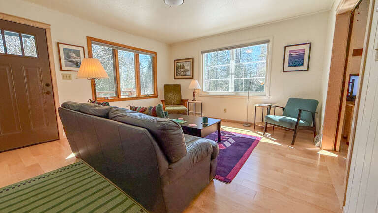 Relax in your bright living room with comfortable seating and lovely woodland views through large windows.