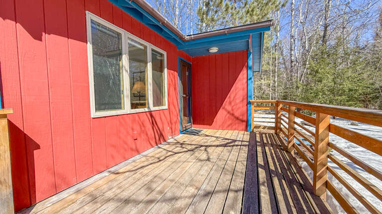 Vibrant red cabin with spacious wooden deck where you can soak up mountain air and forest views in complete privacy.