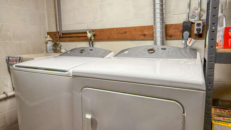 A functional laundry area with washer and dryer stands ready for your use during your stay.
