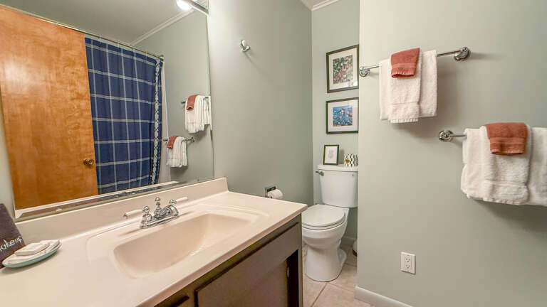 Your private bathroom features fresh towels, soft lighting, and everything you need for a refreshing start to your day. The soothing color palette creates a calm, spa-like atmosphere.