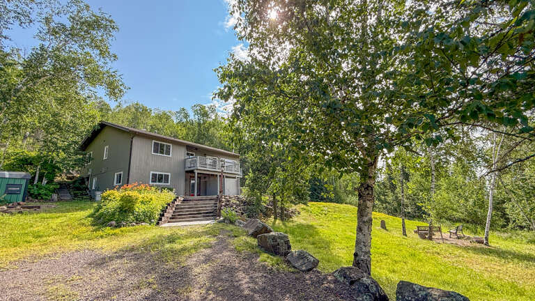 Nestled on a peaceful wooded hillside, this private retreat offers sunny lawns, mature trees, and a welcoming deck where you can unwind with nature all around.