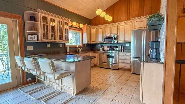 Your spacious kitchen features stainless steel appliances, granite countertops, and a welcoming breakfast bar perfect for morning coffee or casual meals together.