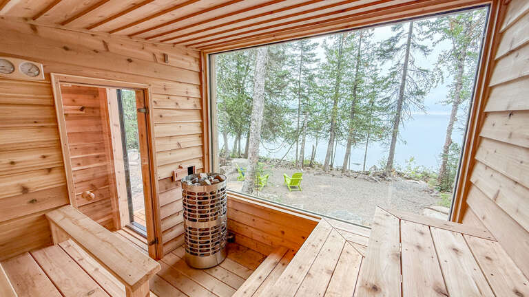 Step into your private lakeside sauna and let the warm wood embrace you while nature unfolds through floor-to-ceiling windows, offering a peaceful escape you won't forget.