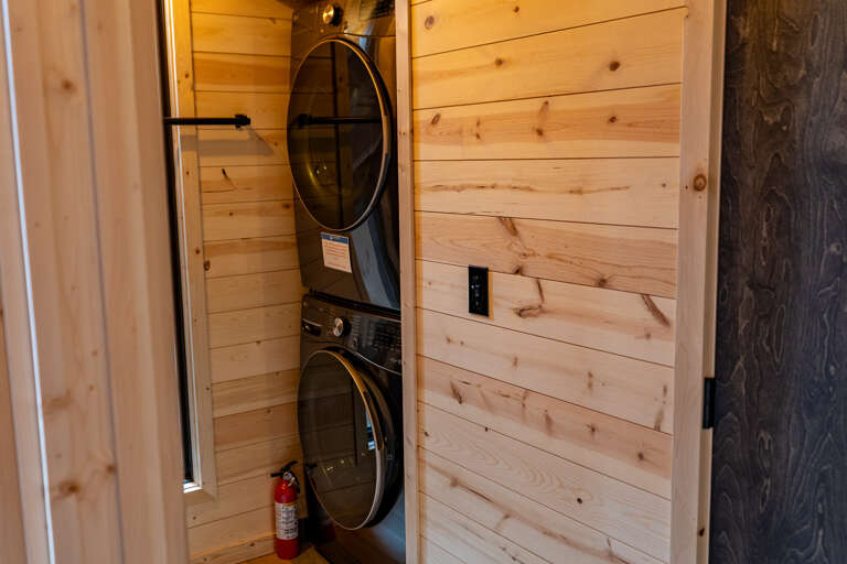 Your laundry essentials are neatly tucked into a private nook with a stacked washer and dryer, making it easy to pack light and refresh your wardrobe anytime.