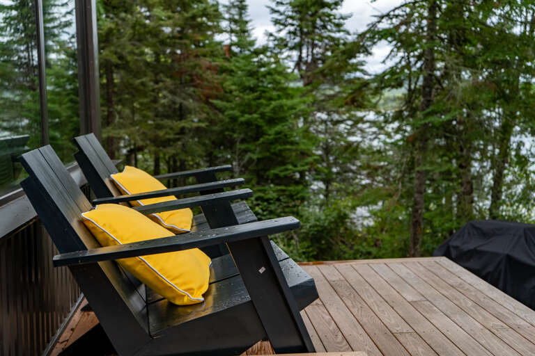 Picture yourself unwinding in these cozy deck chairs, surrounded by towering evergreens and the peaceful sounds of nature—your perfect retreat awaits.