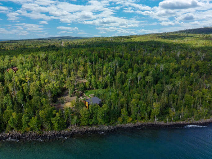 Nestled among dense forest on the shores of pristine blue waters, this secluded lakefront property offers absolute peace and connection to nature.