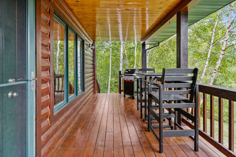 Step outside to your private covered deck with rustic wood finishes, outdoor dining, a BBQ grill, and serene birch forest views—perfect for peaceful morning coffee or evening meals.