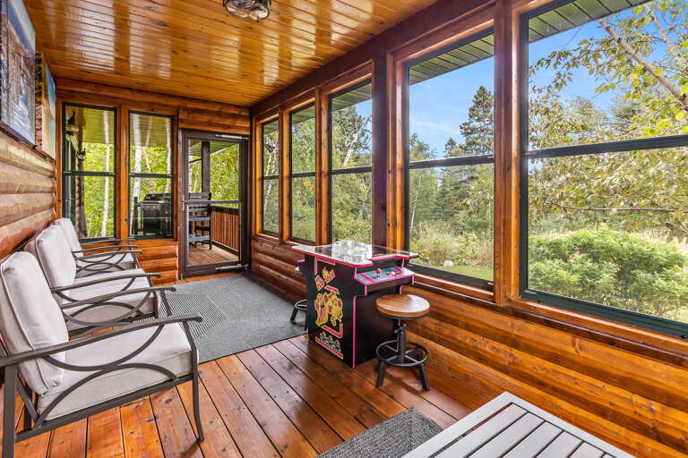 Settle into your private sunroom where floor-to-ceiling windows frame forest views. Challenge friends to arcade games or simply relax in plush seating surrounded by warm wood and natural light.