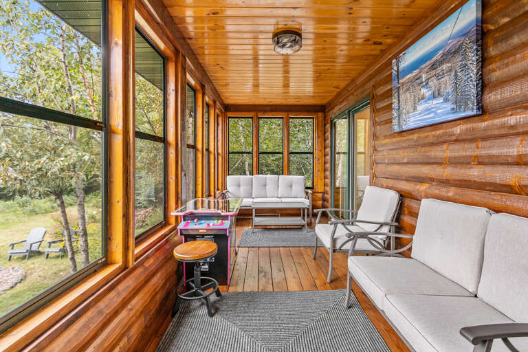 Unwind in your private screened-in porch, where warm wood paneling and comfortable seating create the perfect retreat. Enjoy table games while taking in views of the peaceful outdoor surroundings.