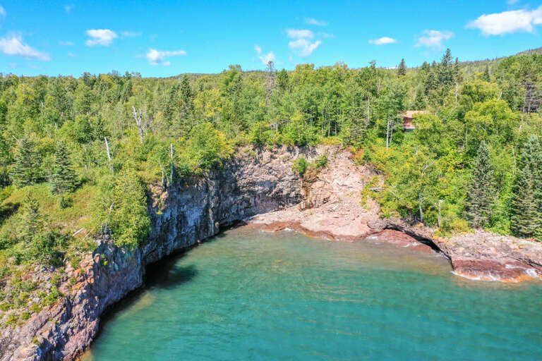 The ledge rock shoreline is located below the home.