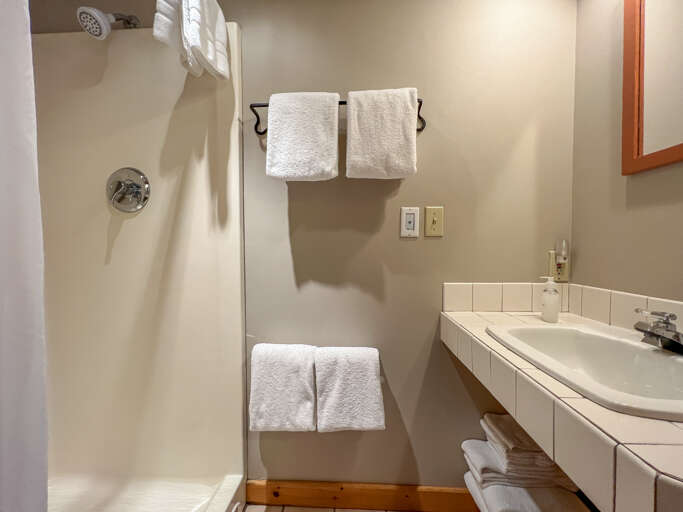 There is a shower and a sink on the right. There is a shower and a sink on the right.