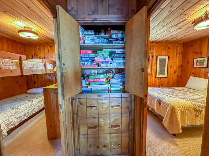 A cabinet full of games is located in between bedrooms 2 and 3.