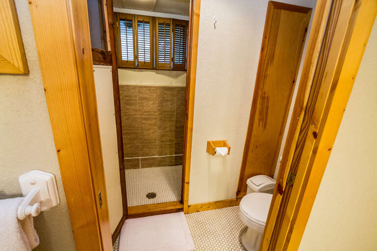 The shower is located through the doorway.