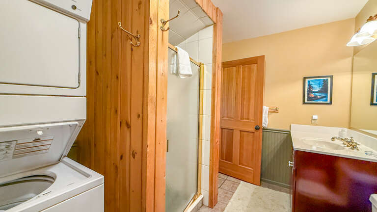 This bathroom also has a stacked washer and dryer.
