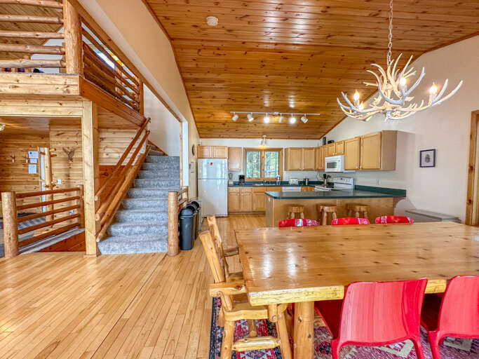 The dining room with the kitchen behind it and the stairs leading to the loft bedroom.