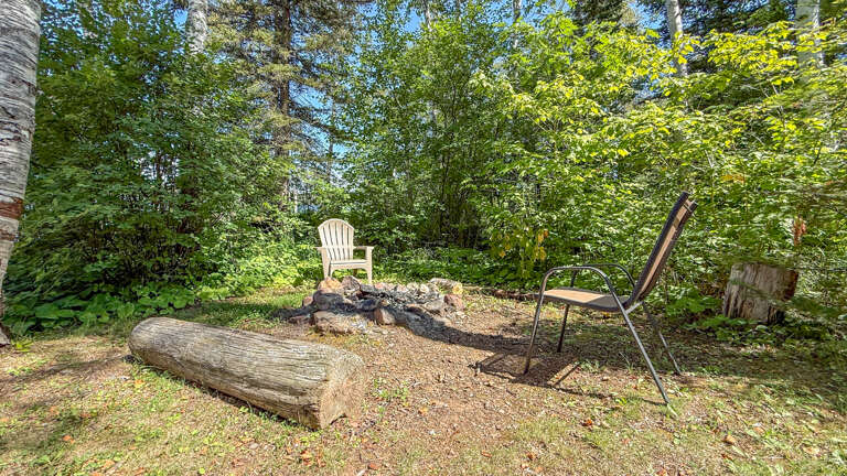 Nestle into your own private fire pit area surrounded by lush greenery. Two cozy chairs await fireside conversations beneath the dappled forest canopy.