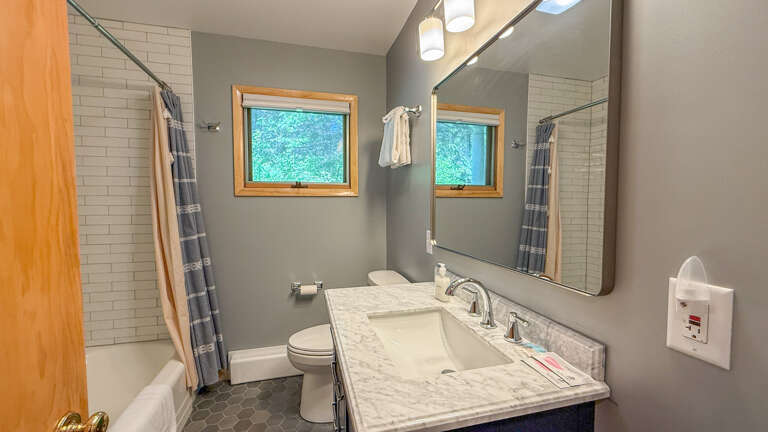 Refresh in your private bathroom with a spacious walk-in shower, natural light from the window, and a sleek marble vanity that makes mornings feel effortless.