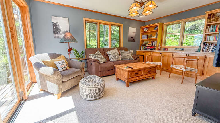 Sink into plush seating in your bright living space, where natural light floods through large windows and warm wood accents create a welcoming retreat for relaxation and quality time.