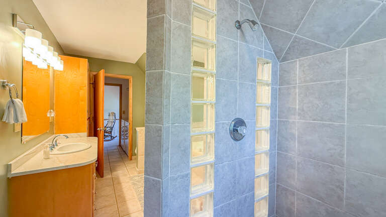 Step into your bright, spacious bathroom with vibrant accents, modern fixtures, and a sleek tiled shower. Fresh towels await to complete your comfort.