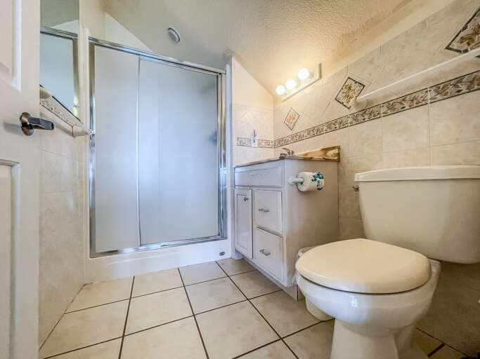 This bathroom is located off of the loft and features a shower.