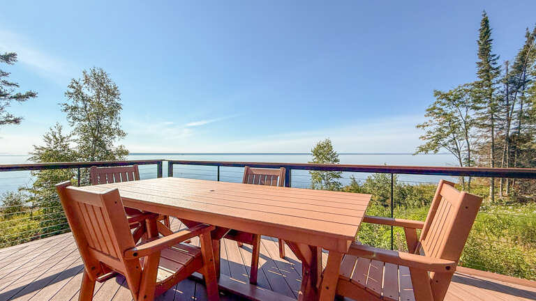Your private deck invites you to unwind with morning coffee or evening cocktails overlooking serene lake waters framed by evergreens and open sky.