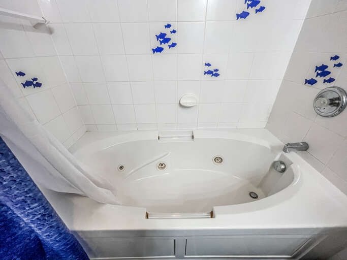 It features a shower/tub combo and a vanity.
