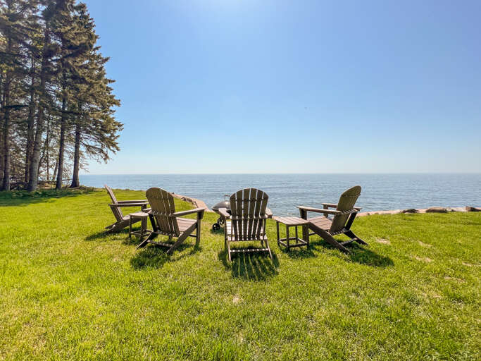 There is a charcoal BBQ, picnic table, and seating around a fire pit.