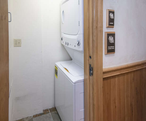 Laundry located in hallway just outside unit