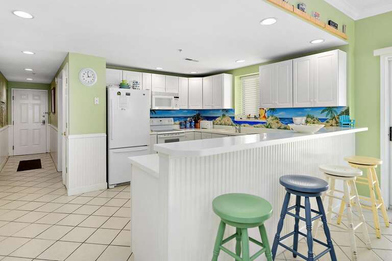 Spacious Kitchen With Pastel Palette, Bar Stools, And Breakfast Counter