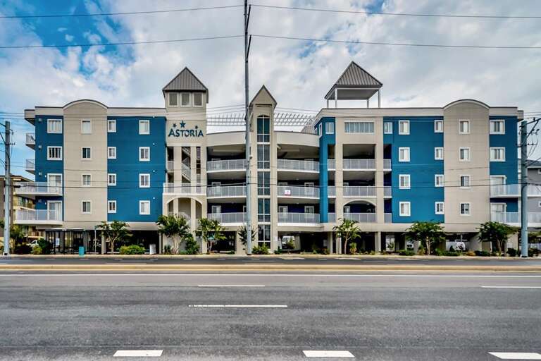 Blue Building With Balconies By Busy Street
