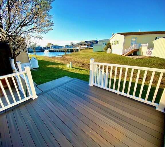 Deck View Of A Lakeside Lawn With Chairs