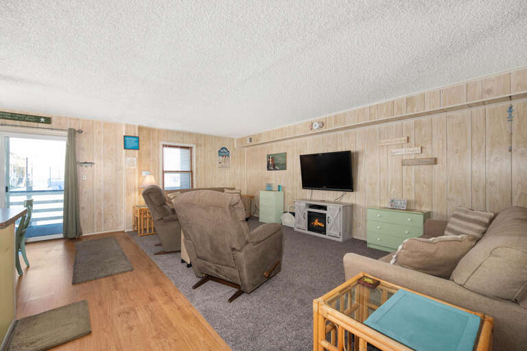 Spacious Living Room With Light Walls, Multiple Seats, And A Television