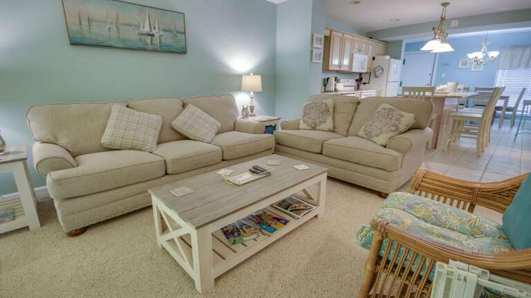 Light-filled Living Space Linked To A Kitchen, Featuring Soft Sofas And Serene Shades