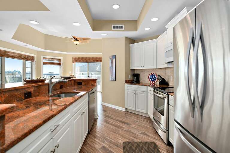Vacation Rental Kitchen With Stainless Steel Appliances And Polished Countertops