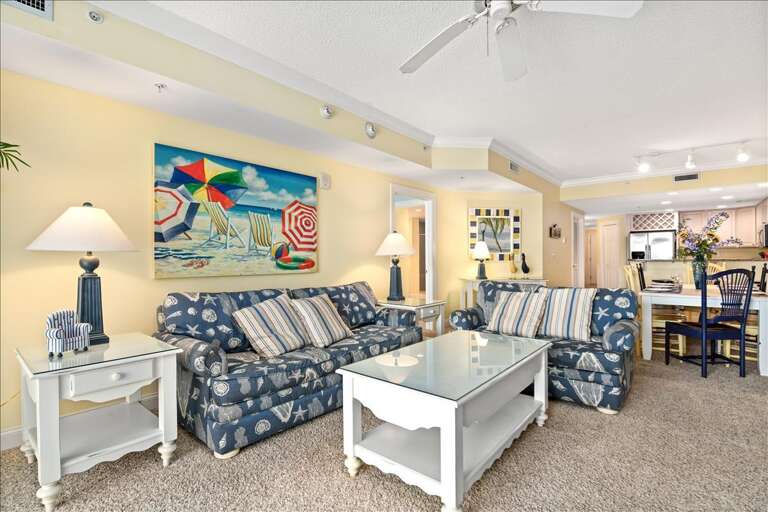 Brightly Lit Living Space With Patterned Sofas And Vibrant Wall Art