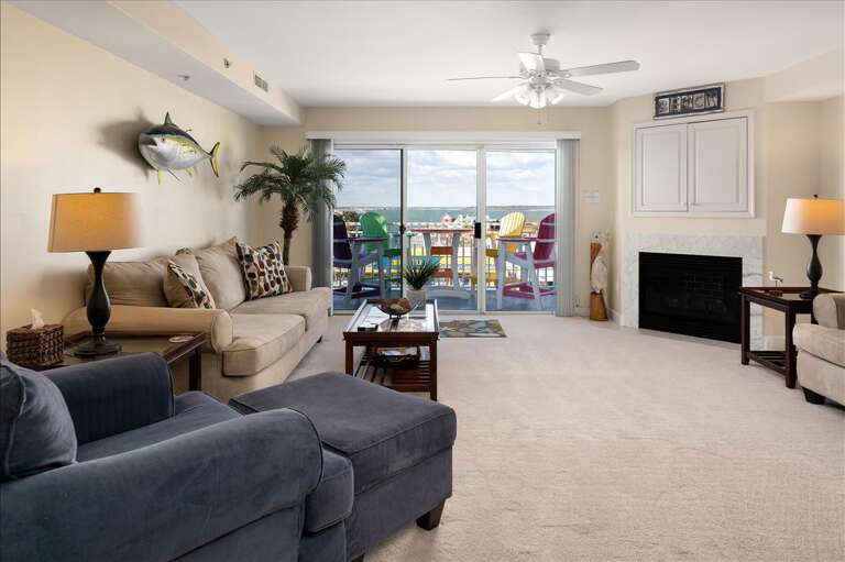 Spacious Living Room With Balcony Access, Ceiling Fan, And Fireplace