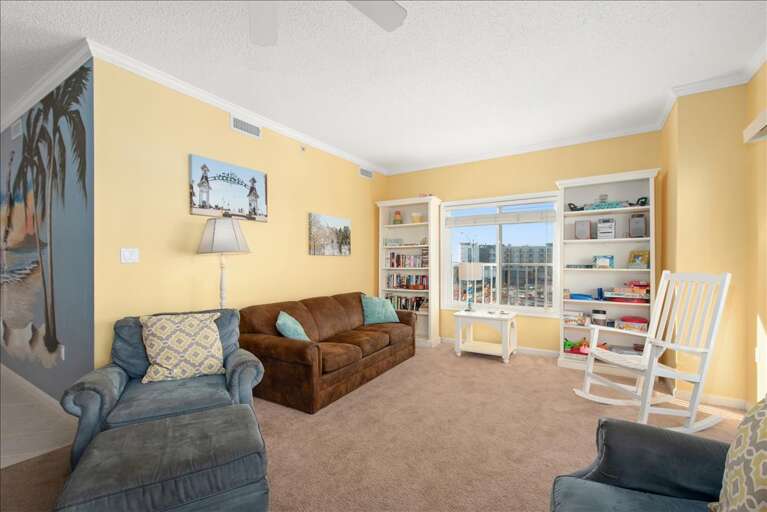 Sunlit Sitting Space With Sofas, Shelves, And Sliding Door To Balcony