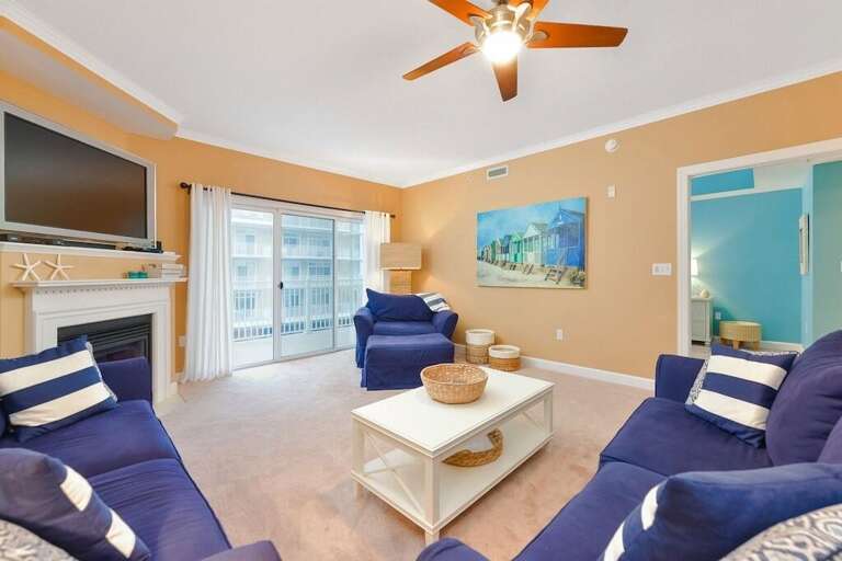 Vacation Rental Living Room With Blue Sofas, White Coffee Table, And Balcony Access