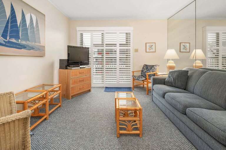 Living Space With Sofa, Sailboat Painting, Shuttered Windows, Neutral Tones