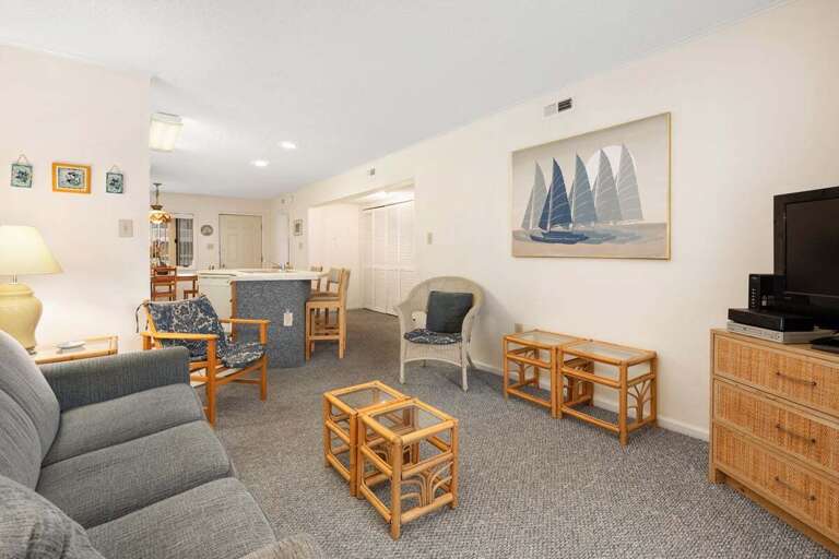 Bright, Bland Living Area With Basic Furnishings And Nautical Painting