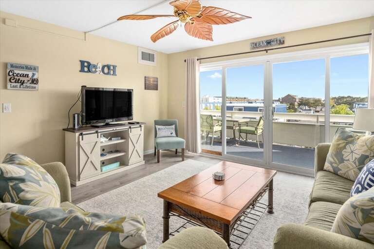 Bright Beachfront Living Area With Large Sliding Glass Doors And Balcony View