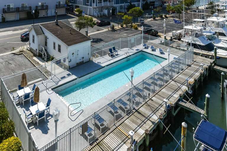 Aerial View Of A Pool By The Pier, Surrounded By Boats And Buildings